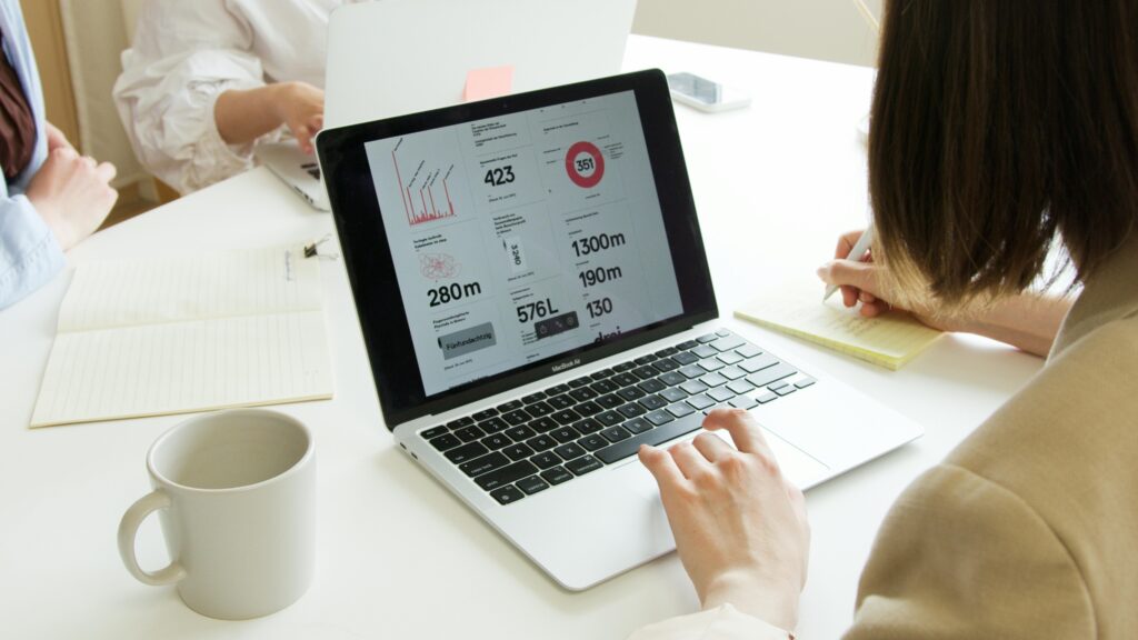 Business meeting featuring laptops, notes, and teamwork around a white table.