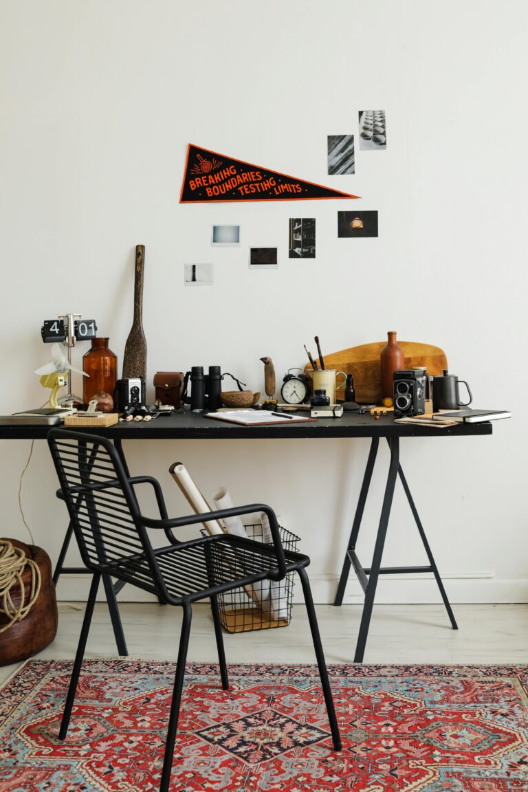 Stylish home office setup with vintage cameras and decor on a black desk.